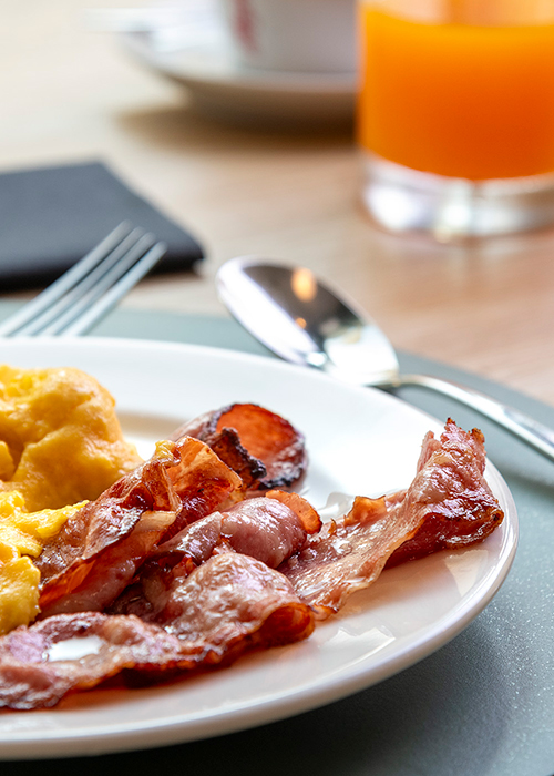 Colazione al MOOM Hotel con uova strapazzate, bacon croccante e succo d’arancia