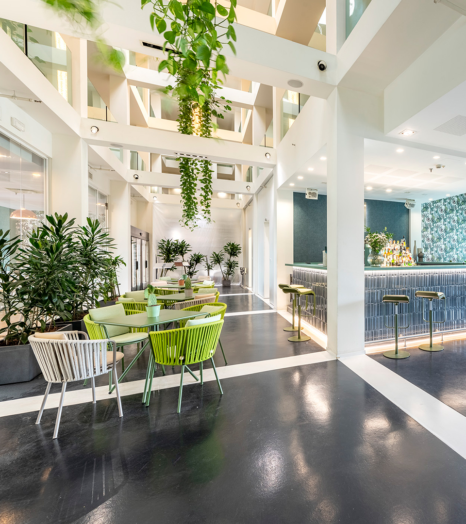 Interni luminosi con piante sospese, decorazioni eleganti e tavolini del bar