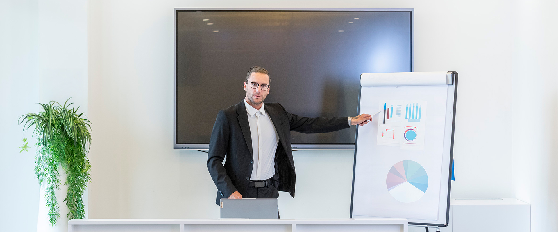 Relatore in abito elegante che presenta grafici su lavagna a fogli mobili