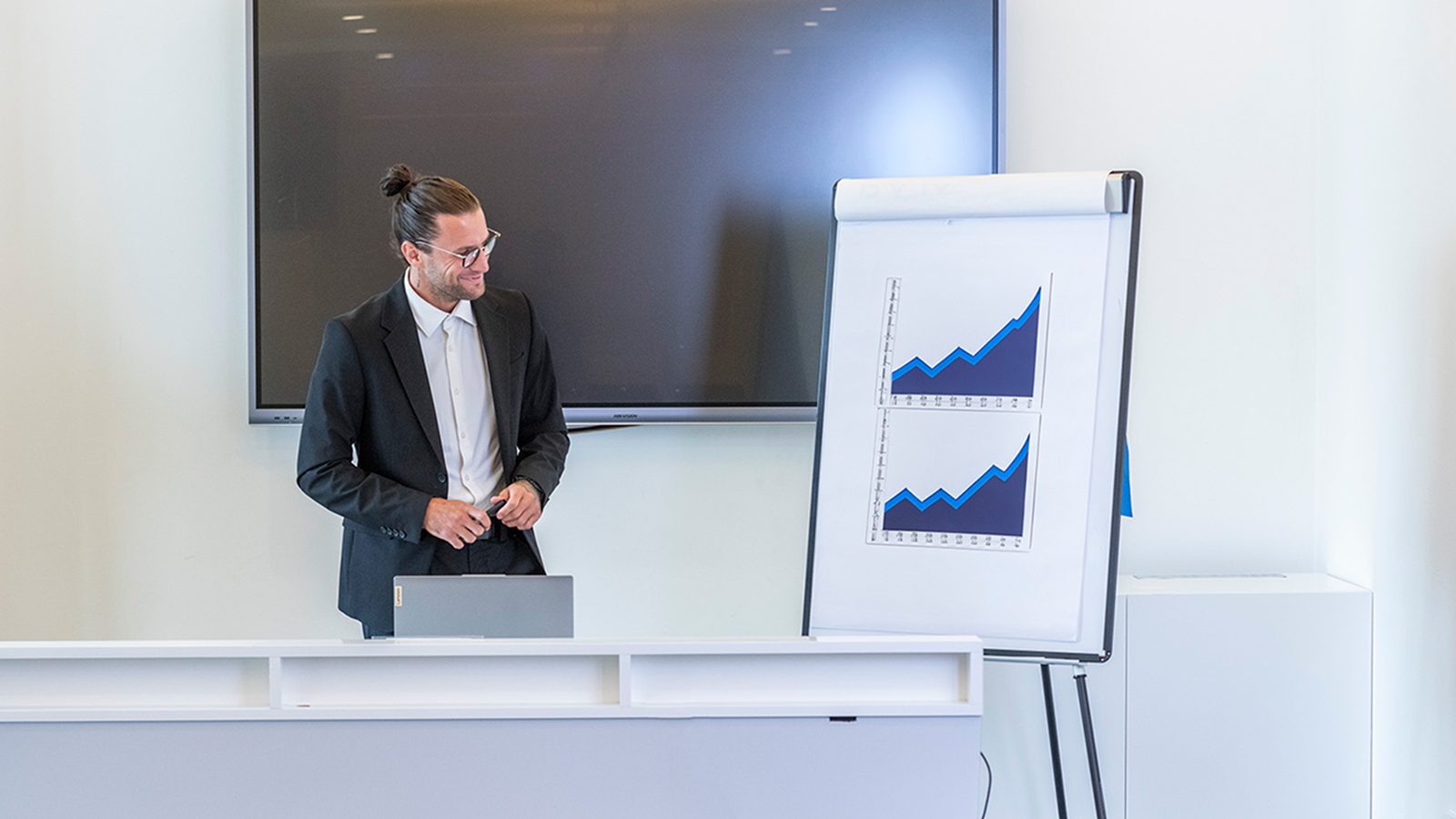 Relatore durante una presentazione business con grafici su flipchart