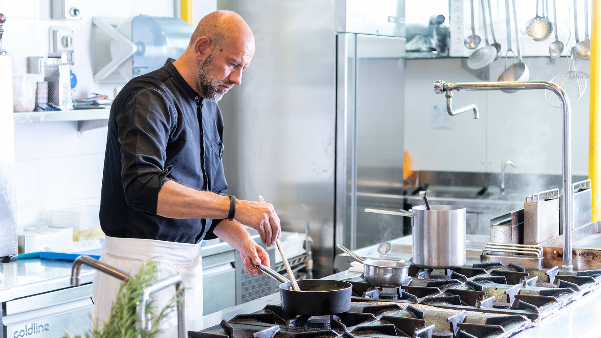 Lo chef del Bloom Restaurant mentre prepara con cura un piatto nella cucina professionale del Moom Hotel