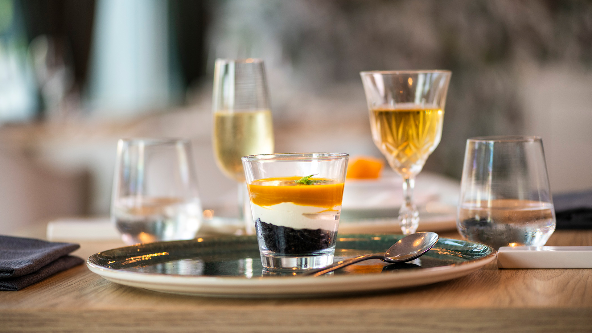 Dessert gourmet a strati in bicchiere, servito al tavolo del Bloom Restaurant con calici di vino in abbinamento