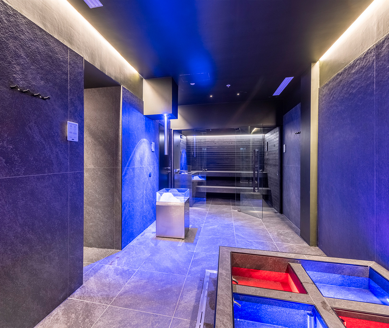 Percorso benessere della spa con sauna, vasche Kneipp e un'atmosfera creata da luci blu per la cromoterapia